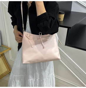 Détail du sac à bandoulière rose clair avec cordon à nœud élégant et sangle réglable