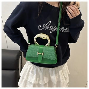 Detail of green sequin handbag with gold metal handle and H-shaped buckle detail