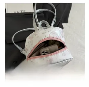 Internal capacity view of mini backpack showing phone and wallet inside main pocket