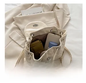 Internal view of beige quilted backpack showing large storage capacity for phone and wallet