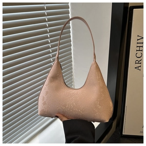 Detail of pink snake-embossed crescent underarm bag with sleek handle and logo