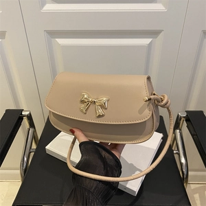Sac à bandoulière abricot avec nœud en métal doré et fine sangle nouée élégante
