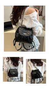 Detail of black mini backpack featuring heart-shaped quilting and silver metal turn-lock