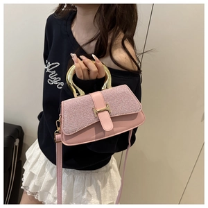 Detail of pink glitter leather handbag featuring round gold handle and metal H buckle
