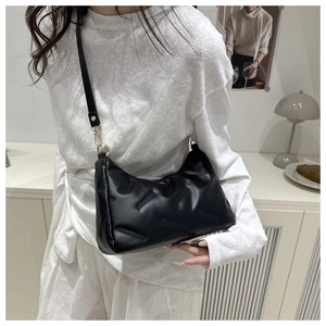 Model trägt eine stilvolle schwarze gesteppte Achseltasche für Pendler und Mode