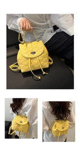Detail of yellow heart quilted PU leather backpack with silver lock and chain strap