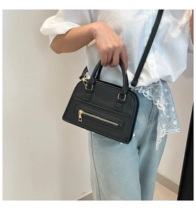 Close-up of black PU leather shoulder bag with lychee texture and gold-tone zippers