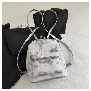 Detail of mini butterfly print backpack with silver leather straps and front pocket