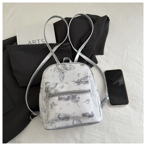 Detail of mini white PU backpack featuring gray butterfly prints and silver straps