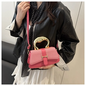 Detail of rose pink handbag with gold H buckle and metallic handle on model