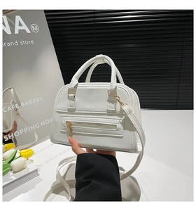 Detailed view of white litchi pattern PU leather texture and gold zipper hardware