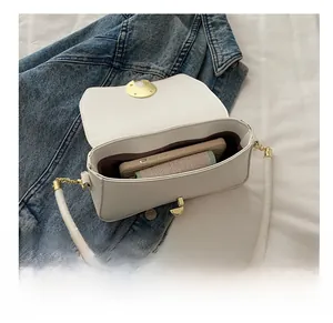 Macro view of white leather crossbody bag interior showing spacious storage capacity