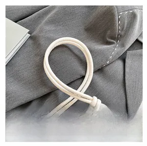 Detail of the white leather knotted shoulder strap with premium golden metal end caps