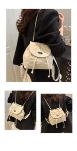 Detail of cream quilted mini backpack with heart stitching and silver turn-lock closure