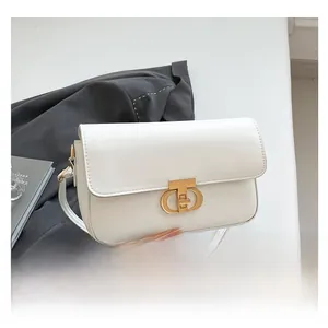 Detailed view of white faux leather crossbody bag with elegant gold circular metal clasp