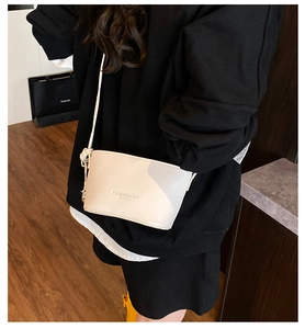 Detail of off-white lychee pattern bucket bag with knot strap and branded embossing