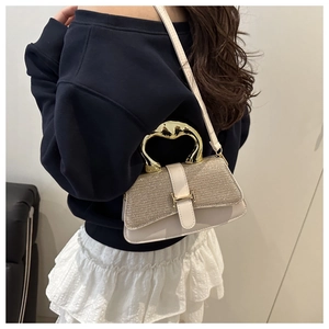 Detail of cream sequin handbag with unique gold irregular handle and metallic H buckle