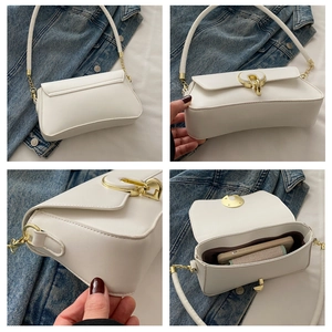 Detail view of white shoulder bag featuring gold ring buckle and spacious brown interior