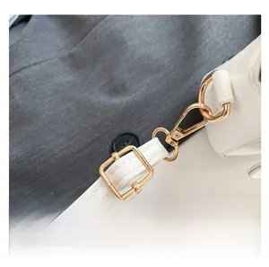 Detail showing white PU leather strap with golden metal lobster clasp and adjuster