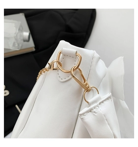Detail of white glossy shoulder bag showing golden D-ring buckle and fine stitching