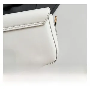 Close-up of fine stitching and gold metal hardware on a white PU leather crossbody bag
