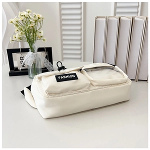 Detail view of cream nylon bag featuring a clear PVC window and fashion woven label