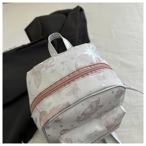 Detail of silver mini backpack with pink butterfly prints and front zipper pocket