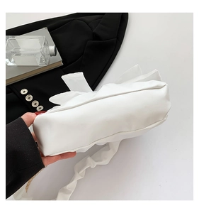 Close-up of a white pleated cloud bag with soft synthetic leather and a gold chain strap