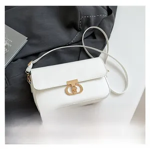 Detailed view of white crossbody bag next to a smartphone for size comparison
