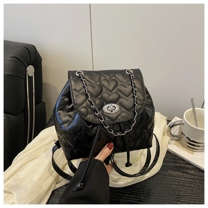 Detail of black heart quilted backpack with silver twist lock and chain strap