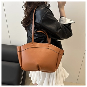 Chic caramel leather bucket bag styled with a minimalist outfit for a modern look