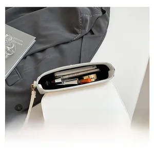 Interior view showing the storage capacity for a smartphone and lipstick in a white PU bag
