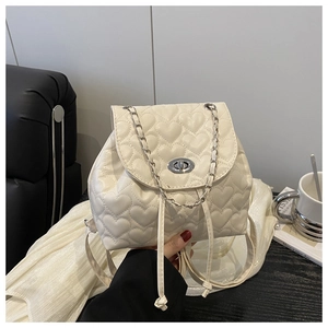 Close-up of heart quilted mini backpack with silver chain straps and metal twist lock