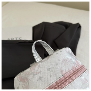 Detailed close-up of textured fabric school backpack with butterfly print and silver handle