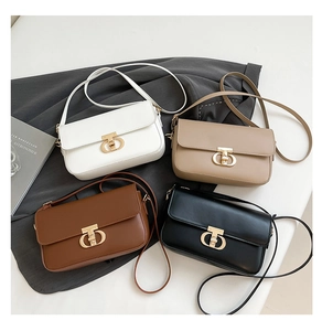 Flat lay of small crossbody bags in white, beige, brown, and black with gold ring buckles