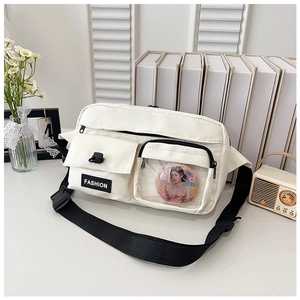Detail of white crossbody bag featuring a transparent PVC pocket with a character badge