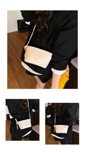 Detail view of cream-white bucket bag with lychee texture and side knot decoration