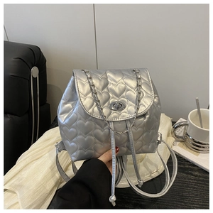 Detailed macro view of silver quilted backpack with heart patterns and metal twist lock