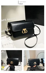 Detailed close-up of a black textured crossbody bag with elegant gold T-shaped buckle