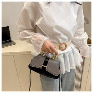 Close-up of contrast crossbody bag with grey woven texture and gold H-shaped buckle