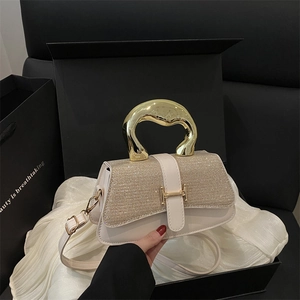 Elegant off-white sequin handbag with gold metal handle on a minimalist background
