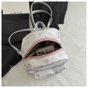 Interior view of small backpack showing capacity for phone and wallet with pink star prints