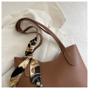 Vue détaillée du sac cabas en cuir marron avec un foulard élégant sur la poignée