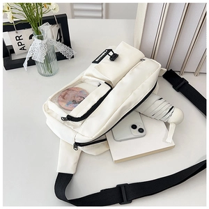 Detail of white multi-pocket crossbody bag with transparent window and black wide strap