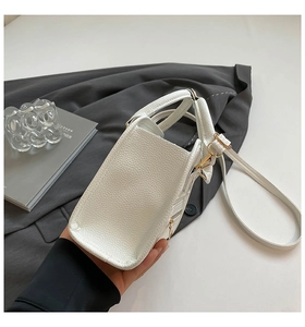 Detail of white lychee pattern Boston bag with gold zippers and detachable strap