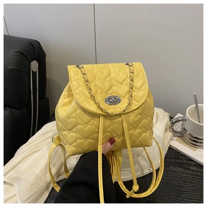 Macro detail of yellow quilted heart stitching and silver twist lock on mini backpack
