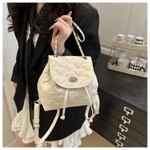 Detail of heart-quilted cream PU leather mini backpack with metal twist lock