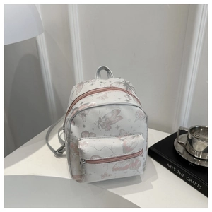 Detailed close-up of a mini backpack featuring pink butterfly prints and silver zippers