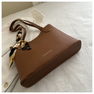 Détail d'un sac cabas marron avec poignée en foulard fleuri et texte doré