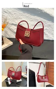 Close-up of a deep red shoulder bag featuring a sleek golden square buckle and matte leather